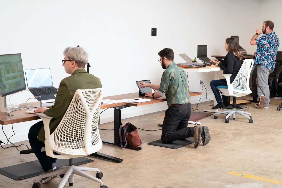 Commercial movers relocating office desks and equipment in an office building