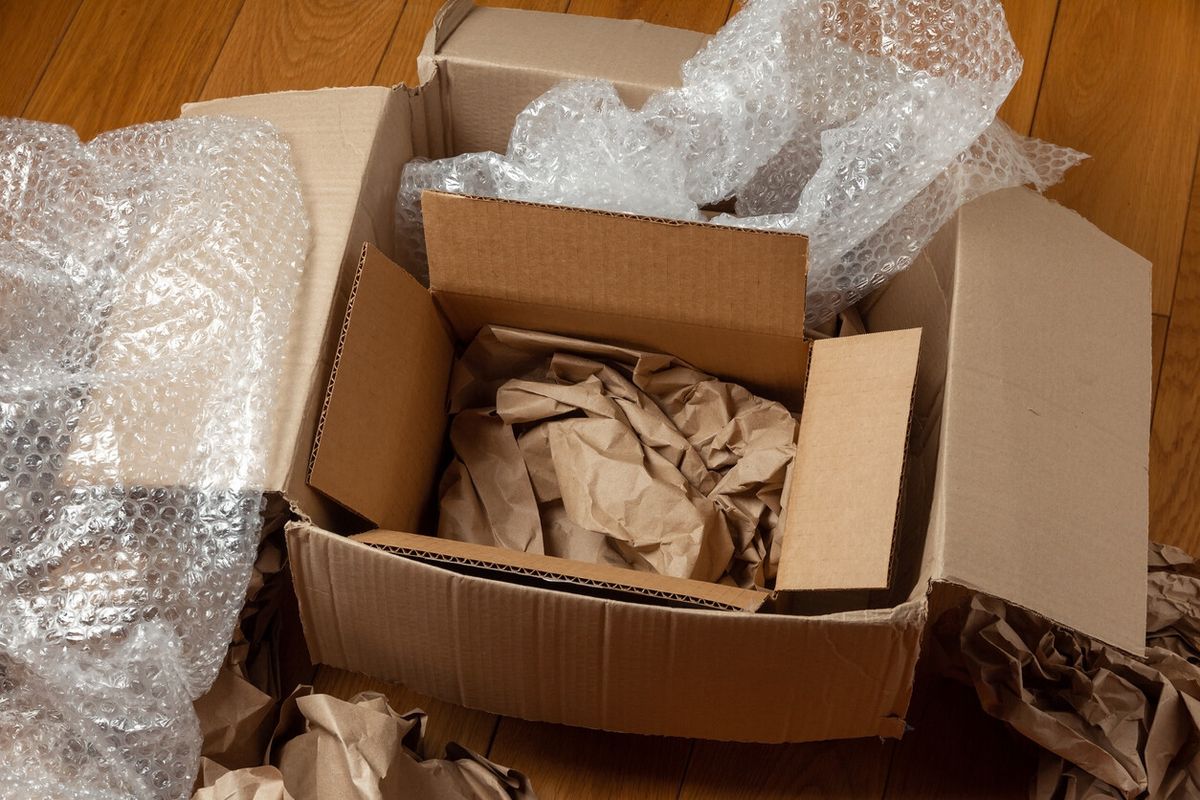 Mover wrapping furniture with bubble wrap and protective packing materials