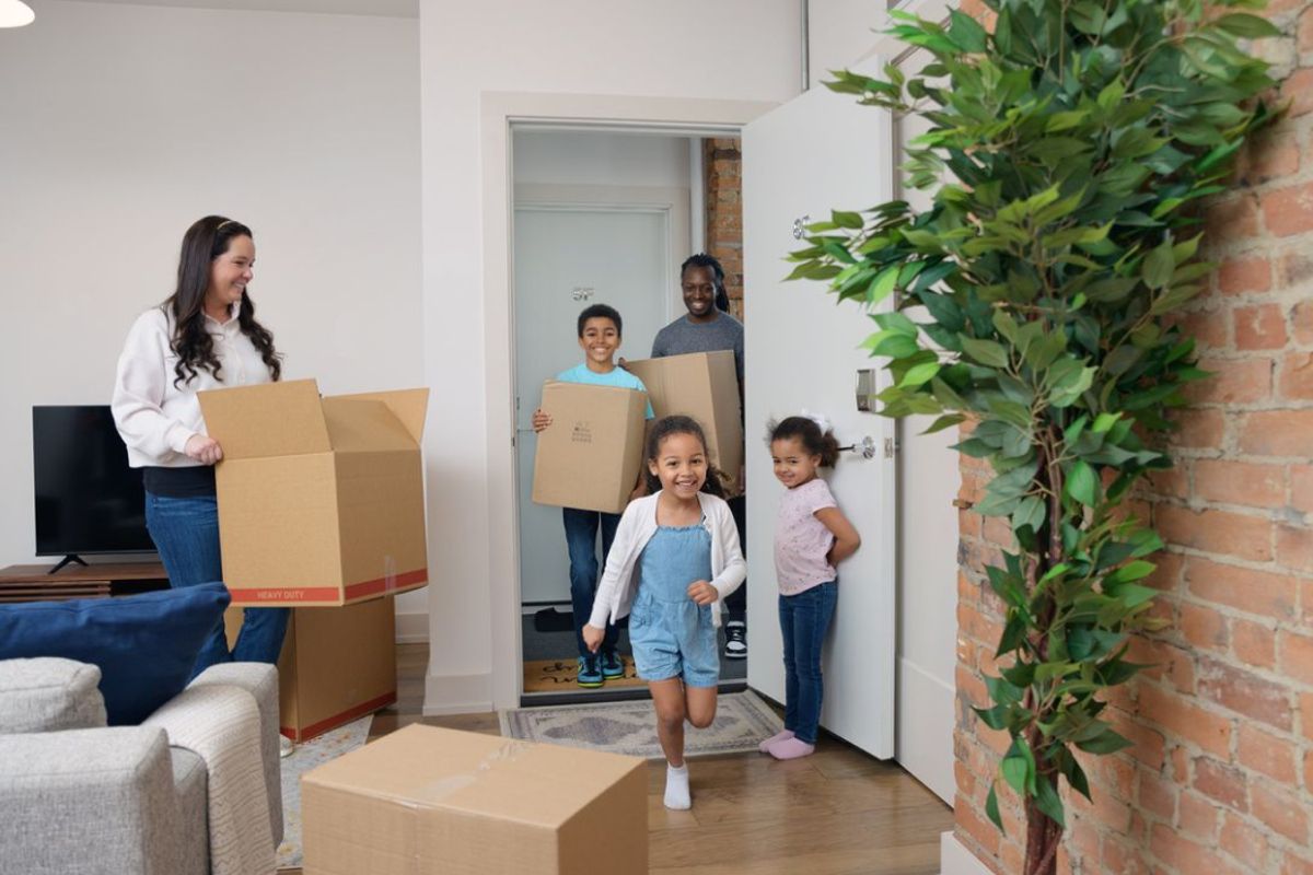 RAK Movers team carrying cardboard boxes into a home during a residential move