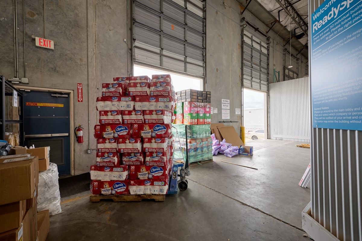 Clean modern warehouse with stacked cardboard boxes on storage shelves